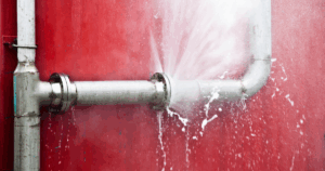 Burst pipe spraying water and licensed Las Vegas plumber from Fast Plumbing provides emergency leak detection and repair service.