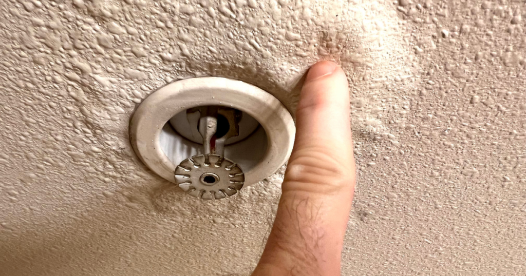 Professional leak detection image showing water damaged ceiling around a fire sprinkler with bubbling texture, indicating early warning signs of a hidden leak in a Las Vegas home.